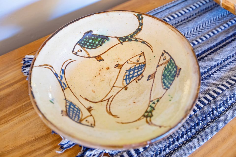 A handmade bowl and runner on the chest provide unique decor on the hutch in the dining area.