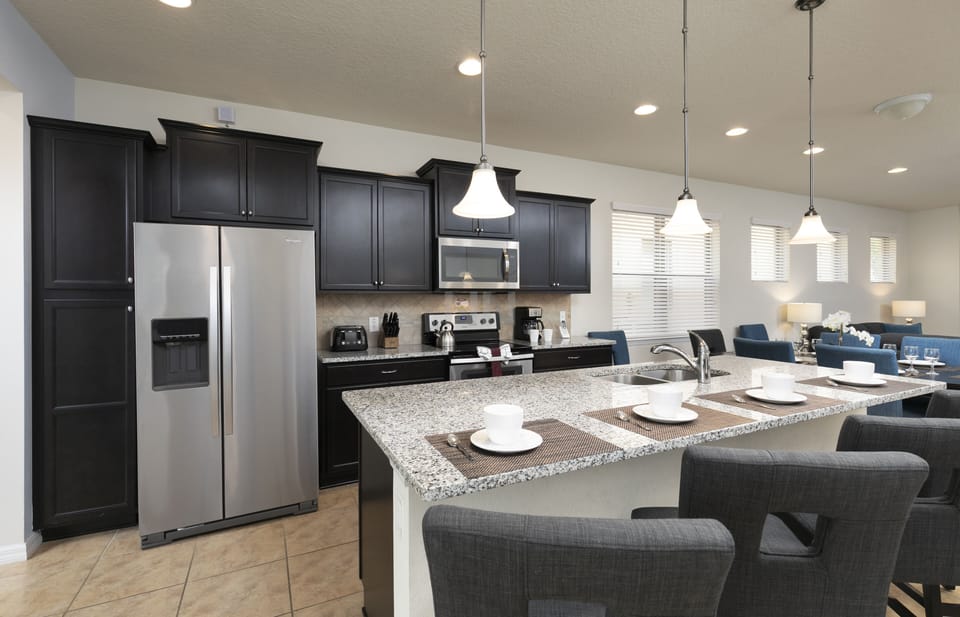 Our sleek dark cabinetry and beautiful island with a sink 