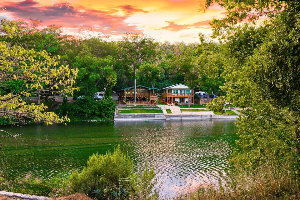 View of the backyard and house from across the river, highlighting the serene riverfront setting and outdoor space.