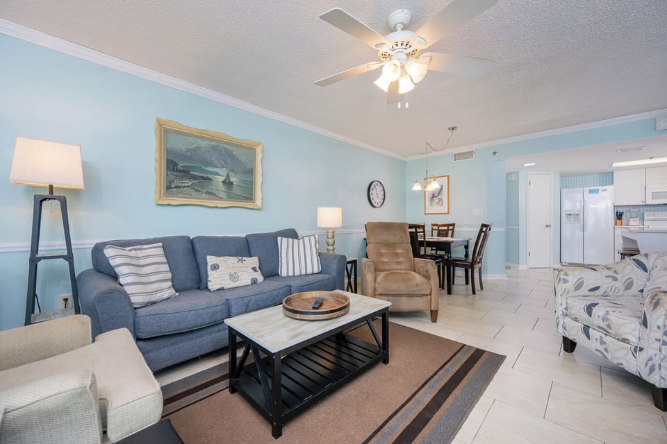 Unwind in the cozy living area, enjoying the gentle coastal vibe and time spent with loved ones on the plush furniture