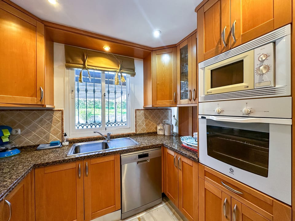 Kitchen with view on carport and back garden 