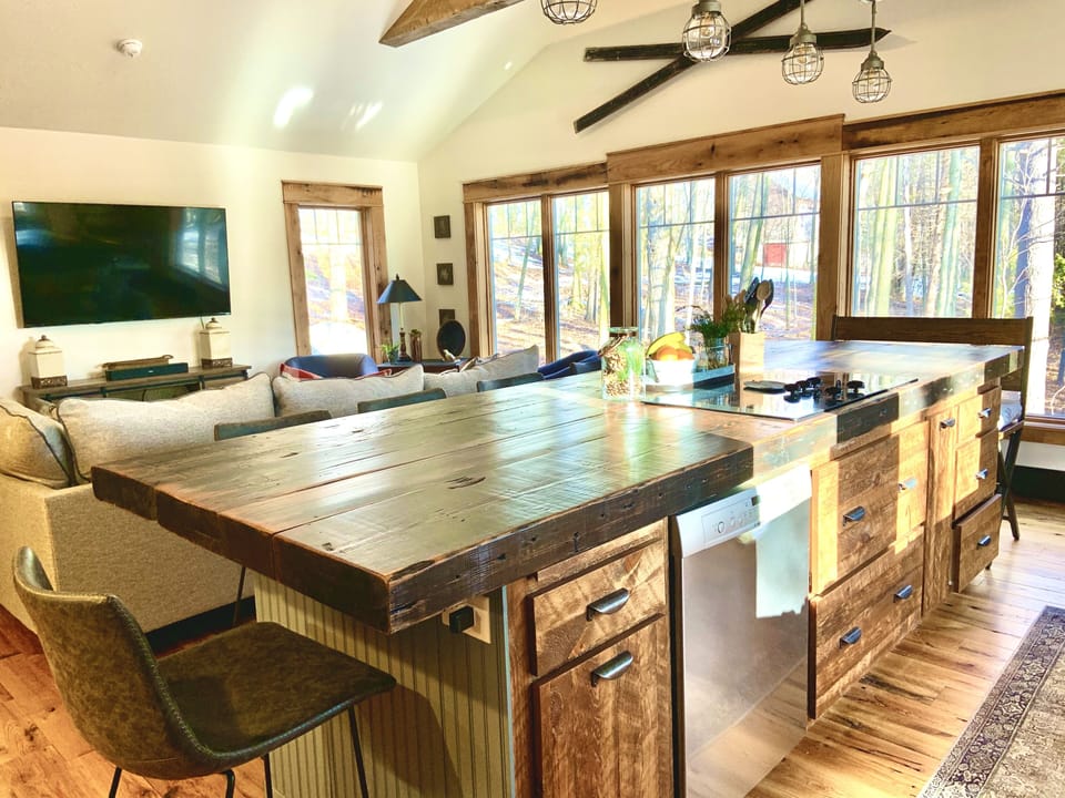 Nice big great room with windows all around, large TV and kitchen all together.