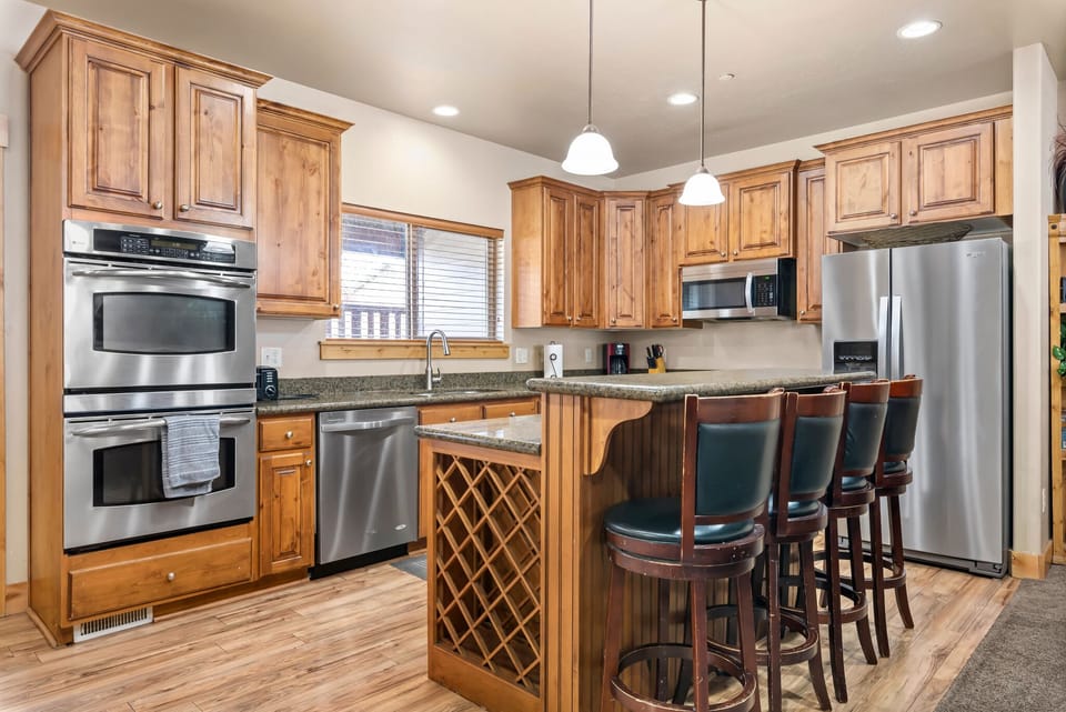 Kitchen with stainless appliances and island seating.