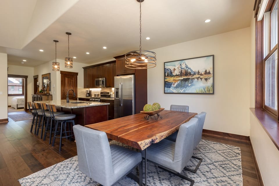 Gather around your stunning live-edge dining table where warm pendant lights create the perfect ambiance for memorable meals together.