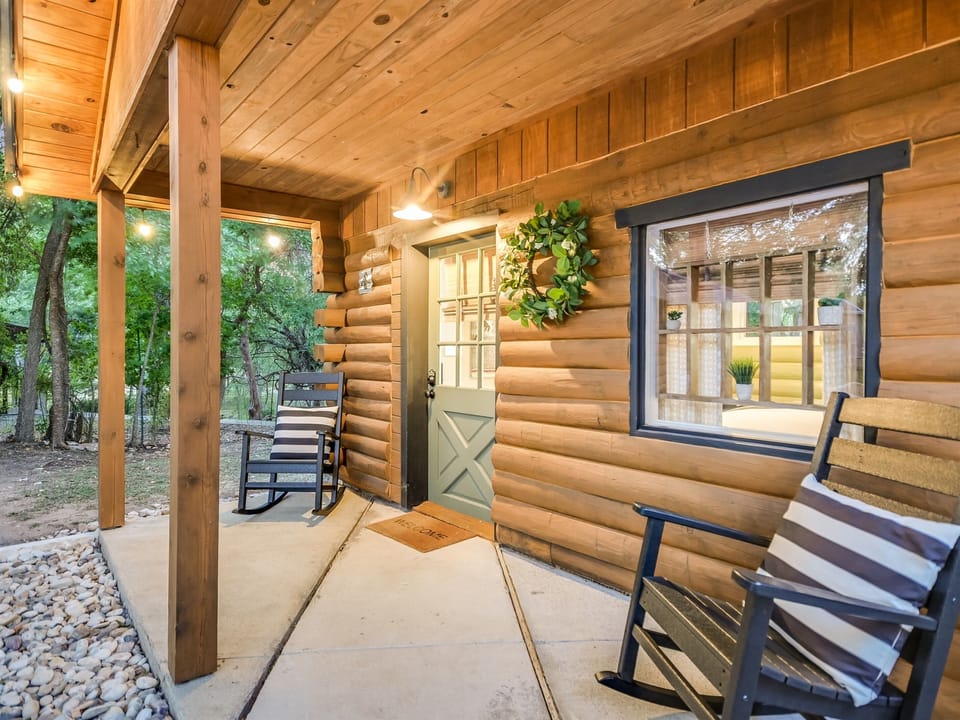Private covered porch with seating outside the Cozy Cabin

