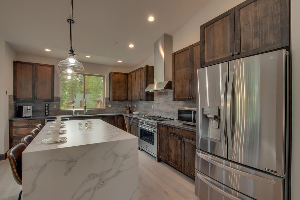 - Modern kitchen with stainless steel refrigerator  
- Large marble island perfect for group gatherings  
- Fully stocked cabin kitchen near Lake Tahoe