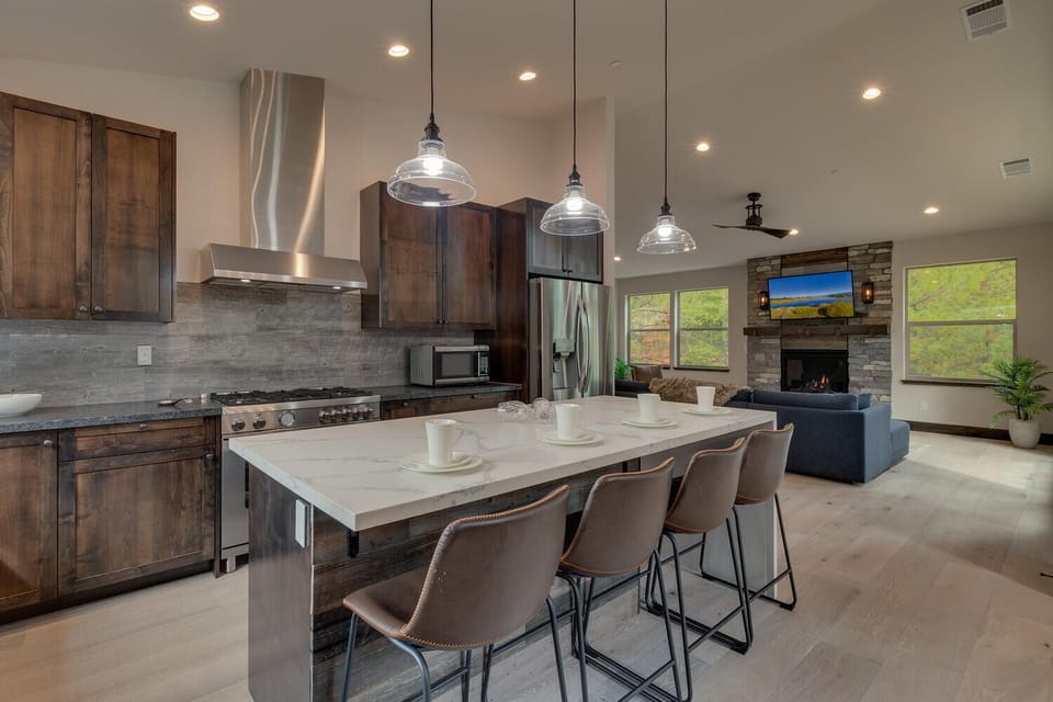 - Open kitchen flows into living room and fireplace  
- Modern appliances and large island with seating  
- Perfect for cooking and entertaining after adventures