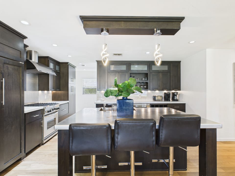 Fully equipped kitchen with stainless steal appliances and a kitchen island with bar seating for 3 guests.