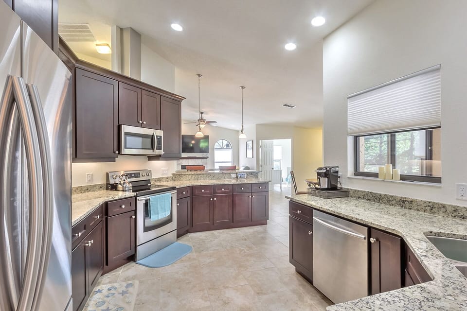 Marble countertops and floor-to-ceiling cabinetry.  Windows overlook pool area.