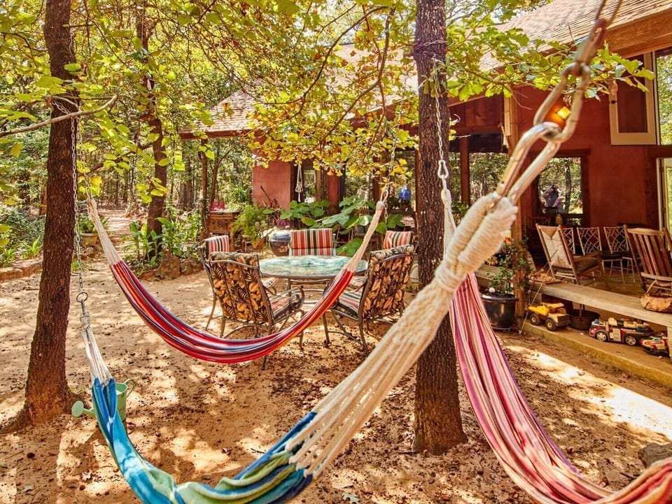 OK. We admit it!  We designed Dragonhead Retreat for kids, tho one grown up is required.   Pictured is Hammock Hangout (1 of 5), table/chairs, walking path to rock garden & lodge parking. To right is outside living area & lodge front door.