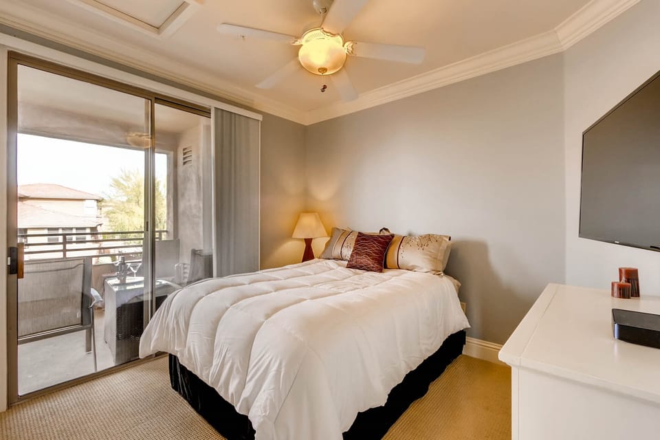 Guest bedroom includes a queen bed, TV and direct access to the patio.