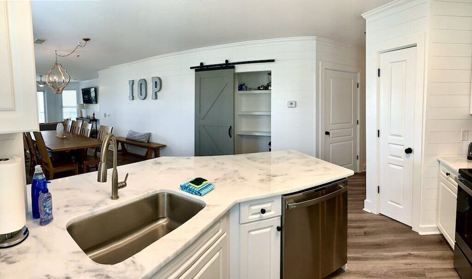 Kitchen with stainless steel appliances and prep island. 208 1140 Ocean Blvd, Isle of Palms, SC | IOP Escapes