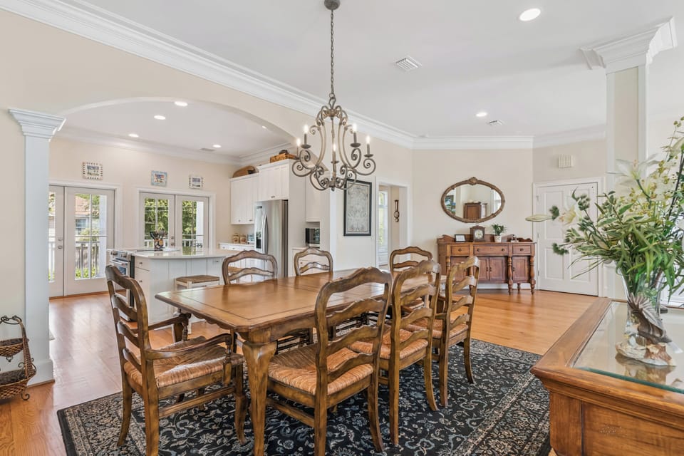 Gather around the handsome dining table where candlelit dinners and lively conversations await. The open layout flows into a bright, fully-equipped kitchen, perfect for your culinary adventures.