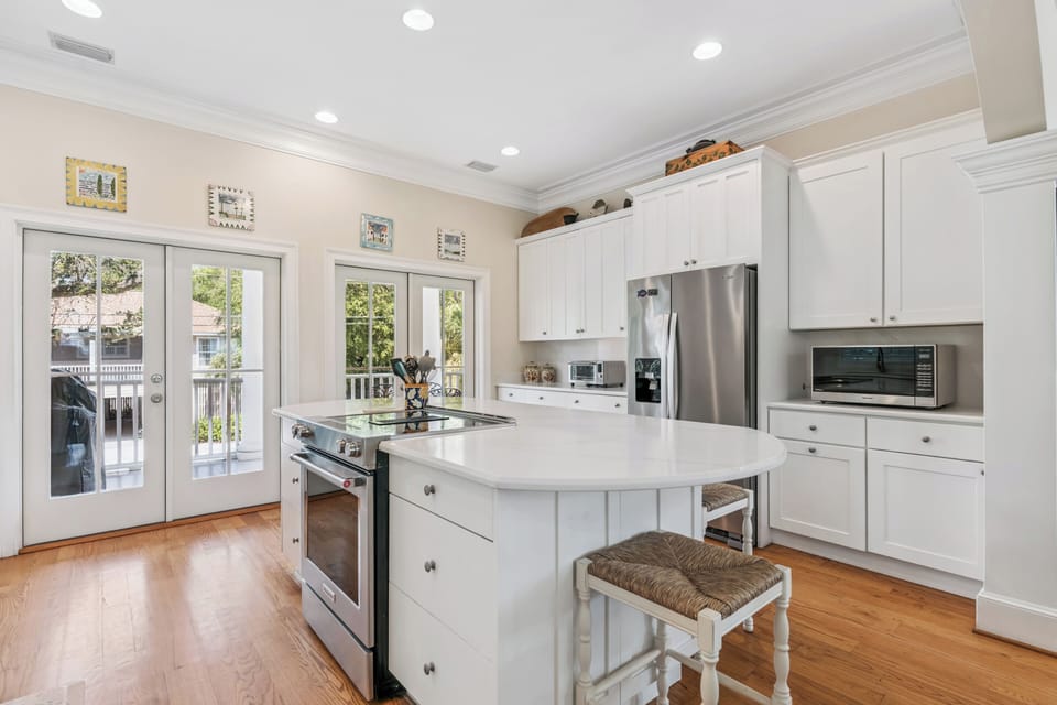 Your fully equipped kitchen features sleek stainless steel appliances, bright natural light, and a center island with seating—perfect for preparing meals and gathering with loved ones.