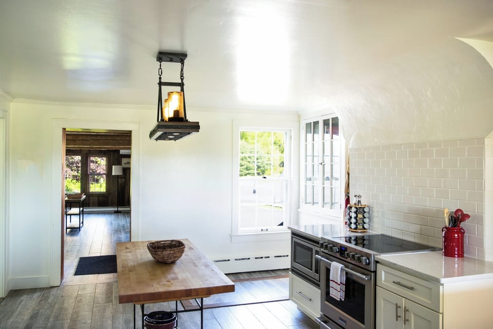 Centrally located kitchen with bright white countertops & tile