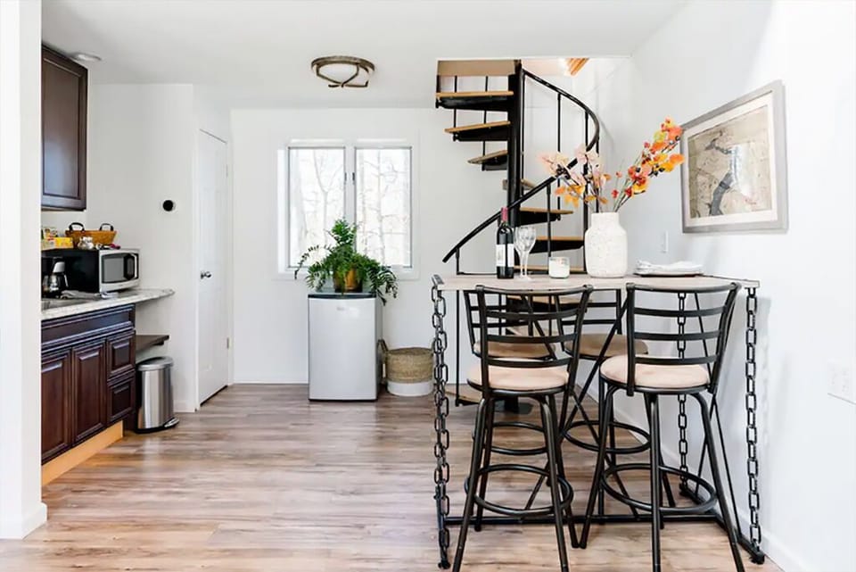 Guest cottage - kitchenette and dining table, staircase leading up to the loft