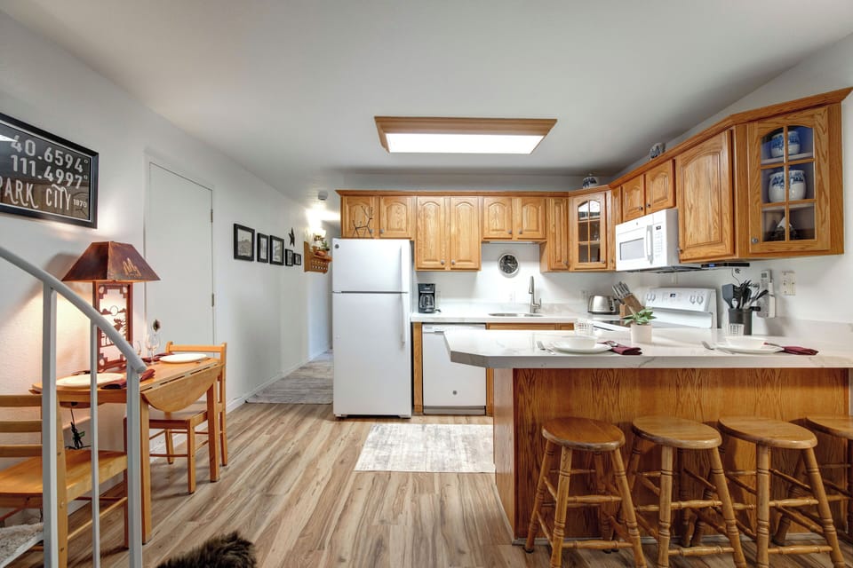 Your fully equipped kitchen features warm wood cabinetry, modern appliances, and a convenient breakfast bar where you can enjoy morning coffee or casual meals.