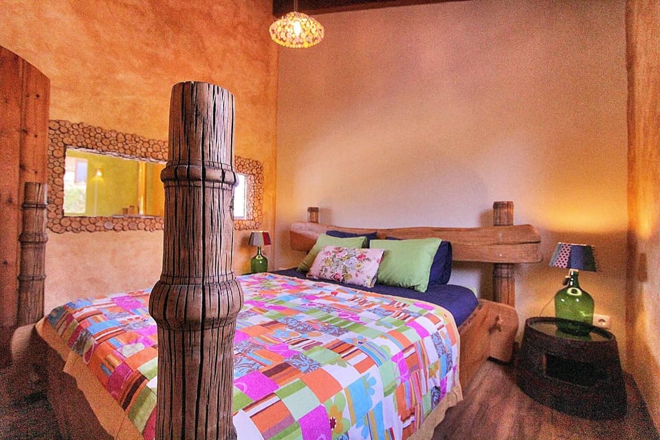 Sleeping area. A bright bedroom featuring a chestnut wooden bed with 18th Century posts from India