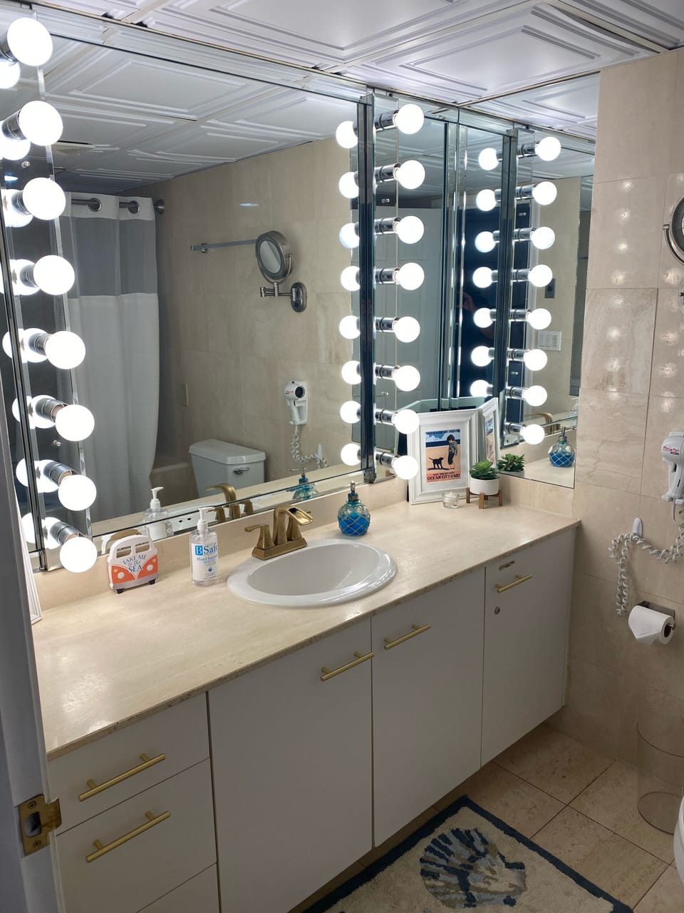 Spacious bathroom with vanity mirror, makeup mirror,  and hair dryer. 