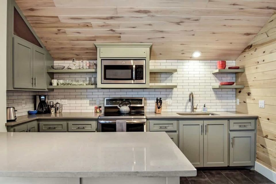 A kitchen with Stainless Appliances, Dishes, and Cookware to make home cooked meals.