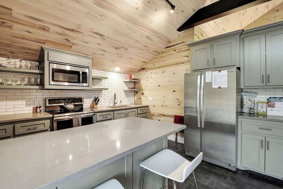 A kitchen with Stainless Appliances, Dishes, and Cookware to make home cooked meals.