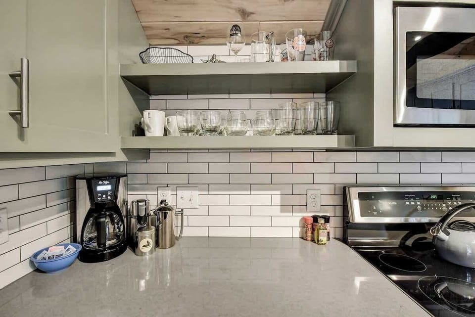 A kitchen with Stainless Appliances, Dishes, and Cookware to make home cooked meals.