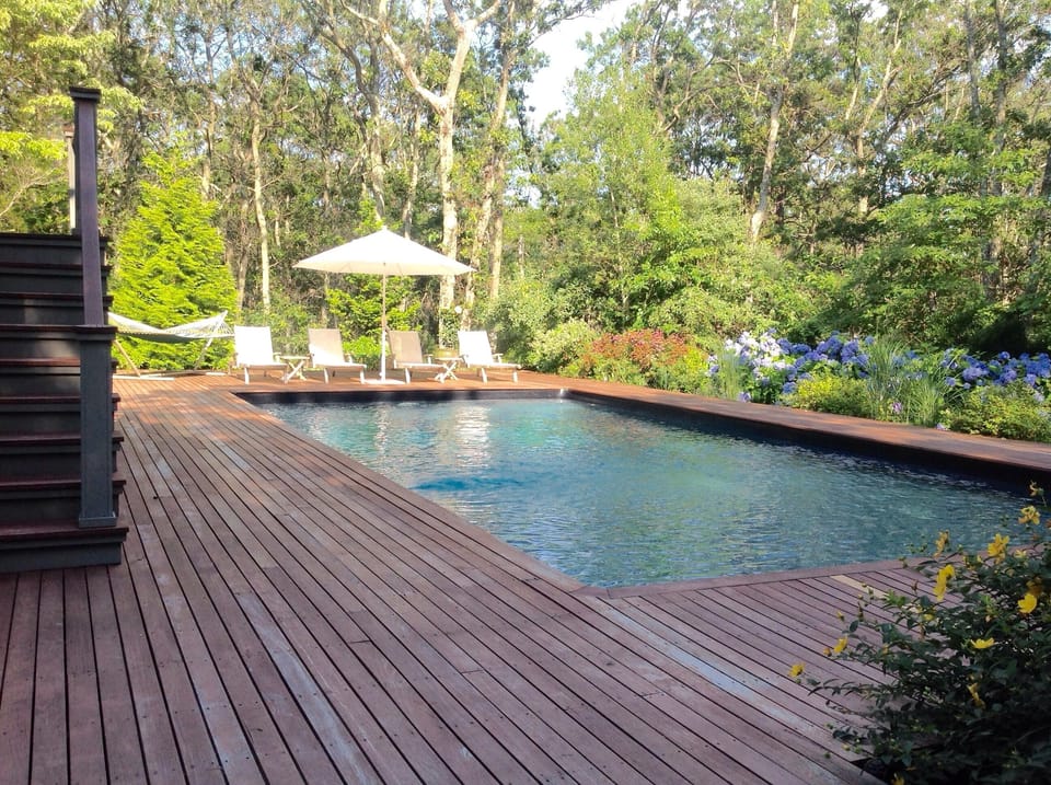 Pool featuring 6 lounge chairs, umbrella and hammock.  