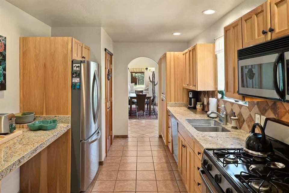 The kitchen is fully equipped with modern appliances and includes a Refrigerator, Gas Stove - Propane, Coffee Maker, Microwave, Toaster, Cookware and Dishwasher