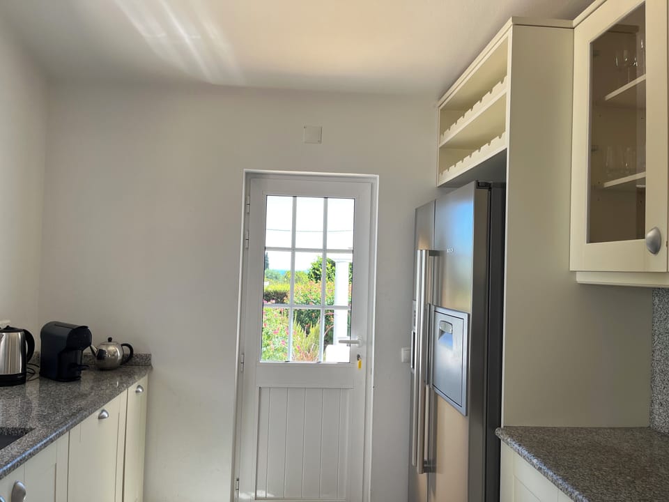 The kitchen is spacious and has access to the BBQ area.