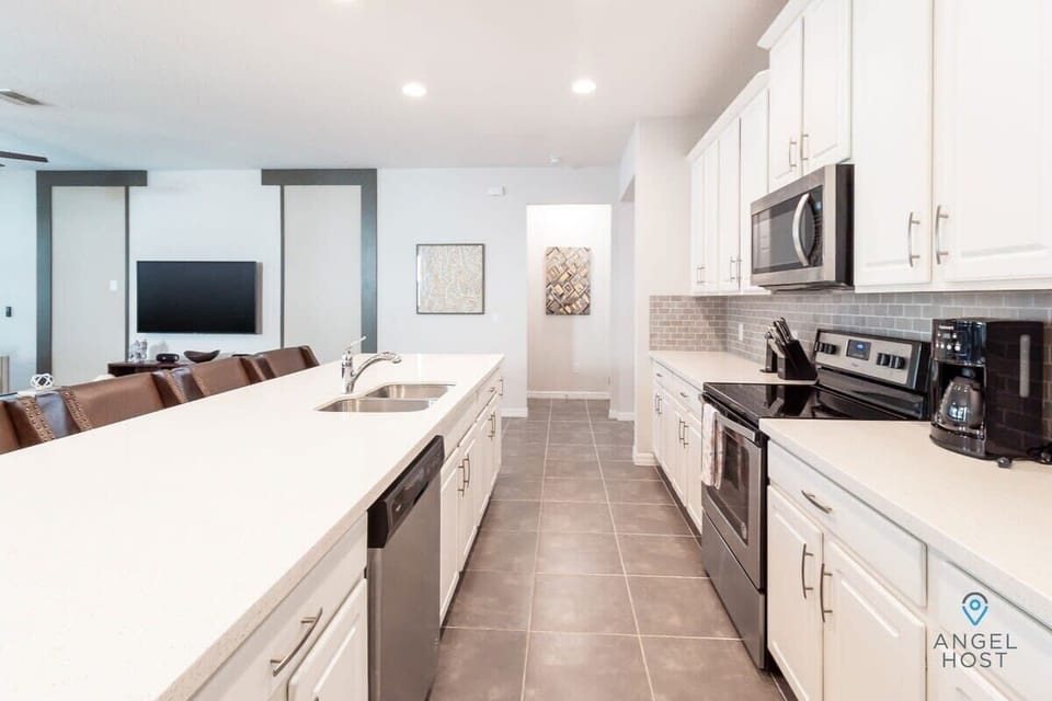 The kitchen includes a fridge, oven, cooktop, microwave, dishwasher, and coffee maker.