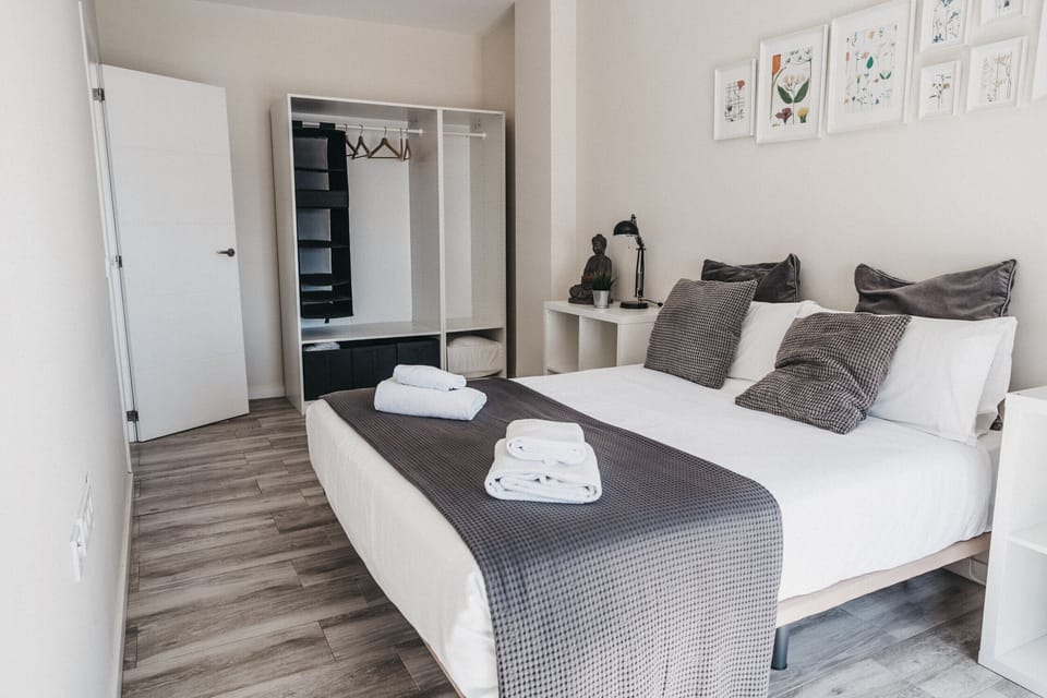 Modern and bright bedroom with double bed and balcony overlooking the beach