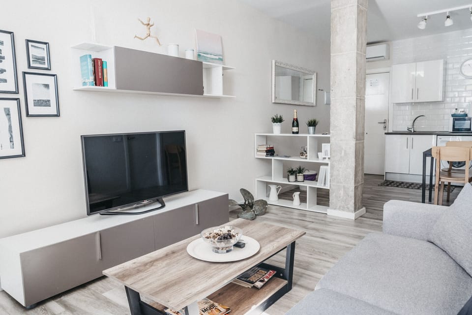 Bright living room with sofa, air conditioning, and all the comforts