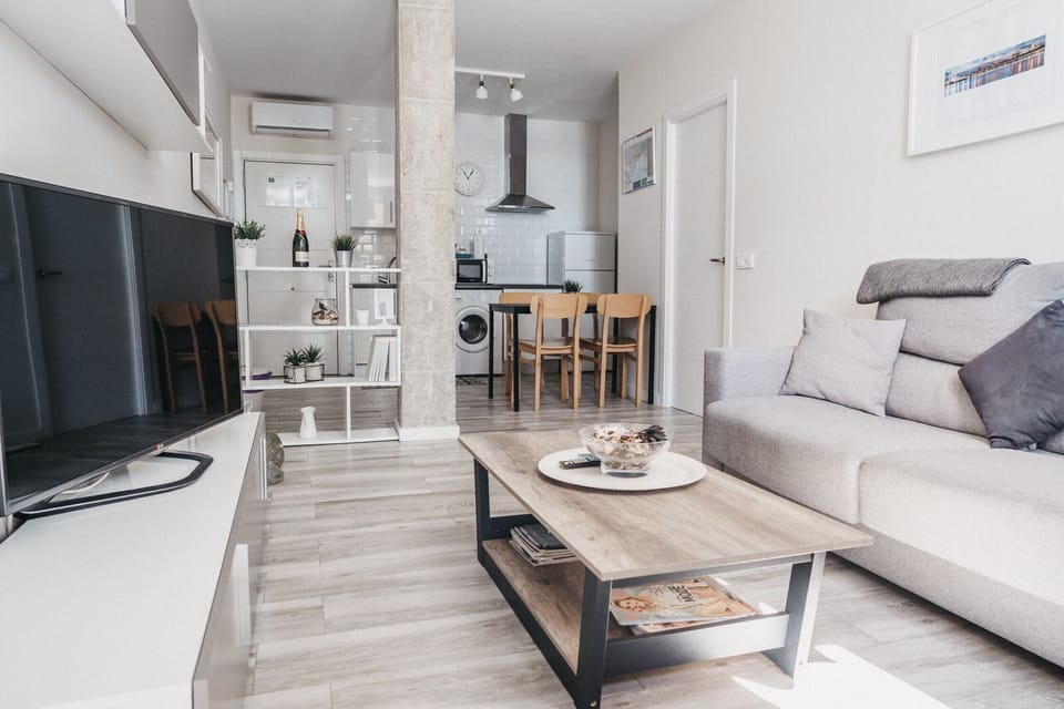 Bright living room with sofa, air conditioning, and all the comforts