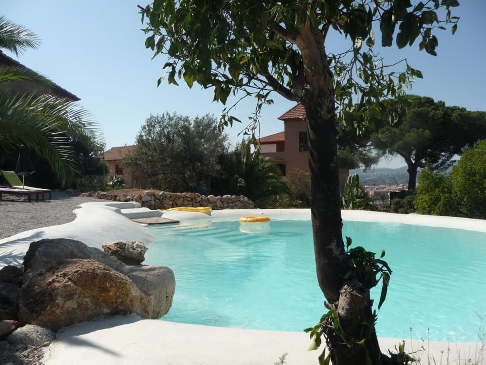 Pool. The natural lake-shaped pool amd the 2 bodies with the  tworoom suites and the threerooom suites in the background