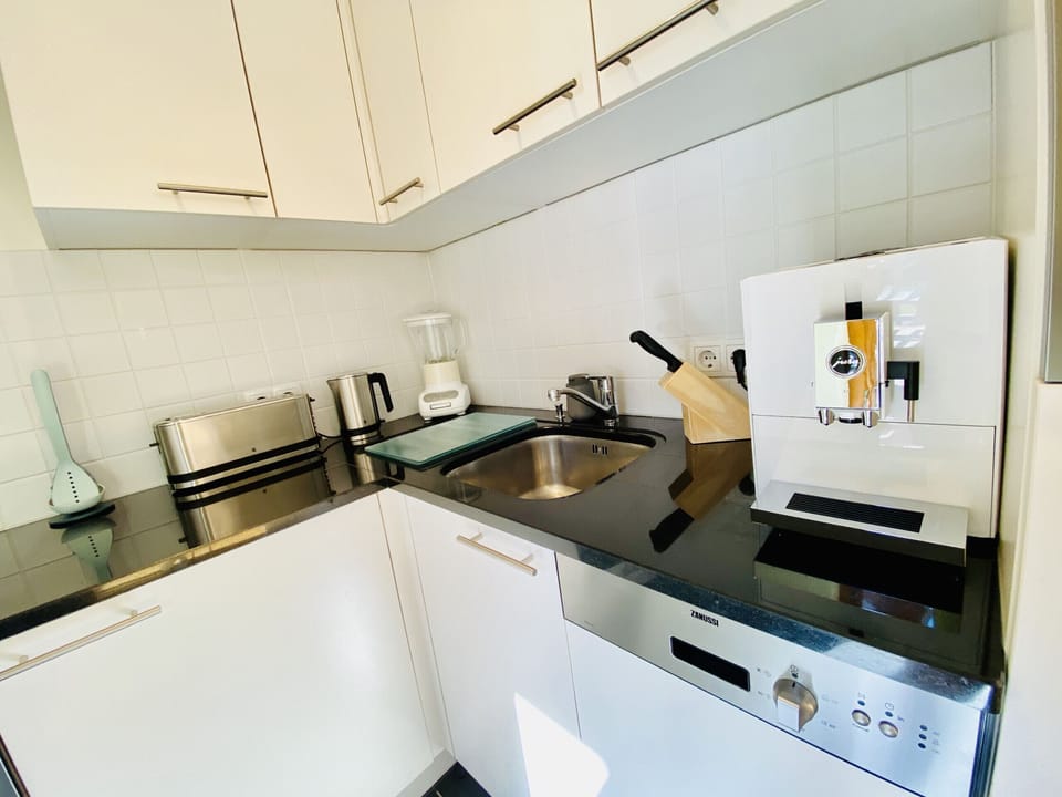 Here you can see the kitchen, which looks inconspicuous at first glance, but really packs a punch. It is equipped in a highly modern way and there is really nothing missing here to cook all sorts of meals.