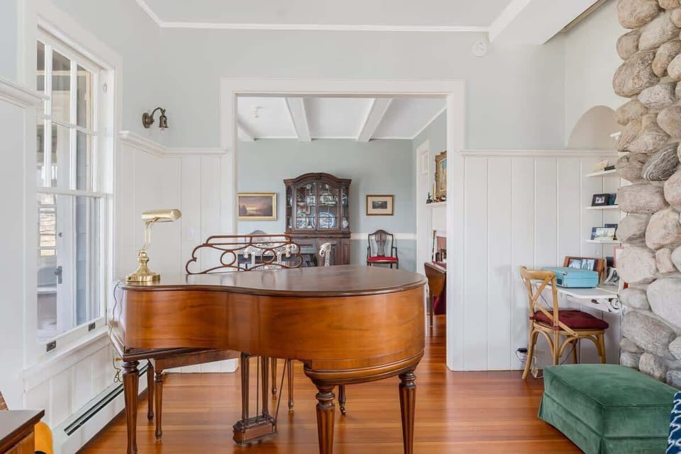 Vintage Baby Grand Piano between the living and dining rooms lets the pianist look out over the water while filling the house with music for their happy family and friends.