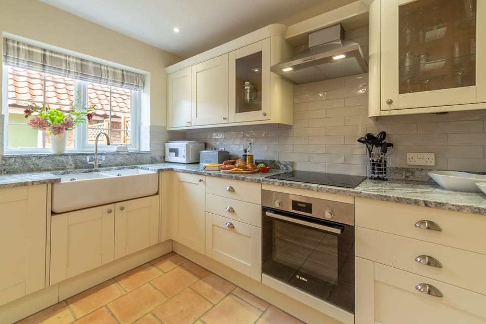Ground floor: Kitchen with double Belfast sink, electric cooker and hob, microwave, fridge/freezer and dishwasher