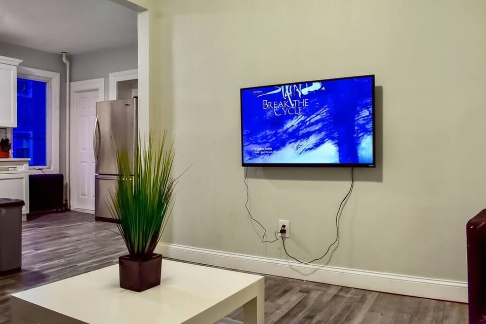 Cozy living area with wall-mounted flat screen TV and built-in Roku