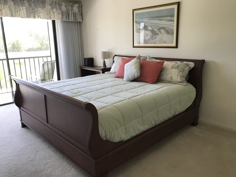 Master bedroom with screen in balcony. View of golf course and pond.  