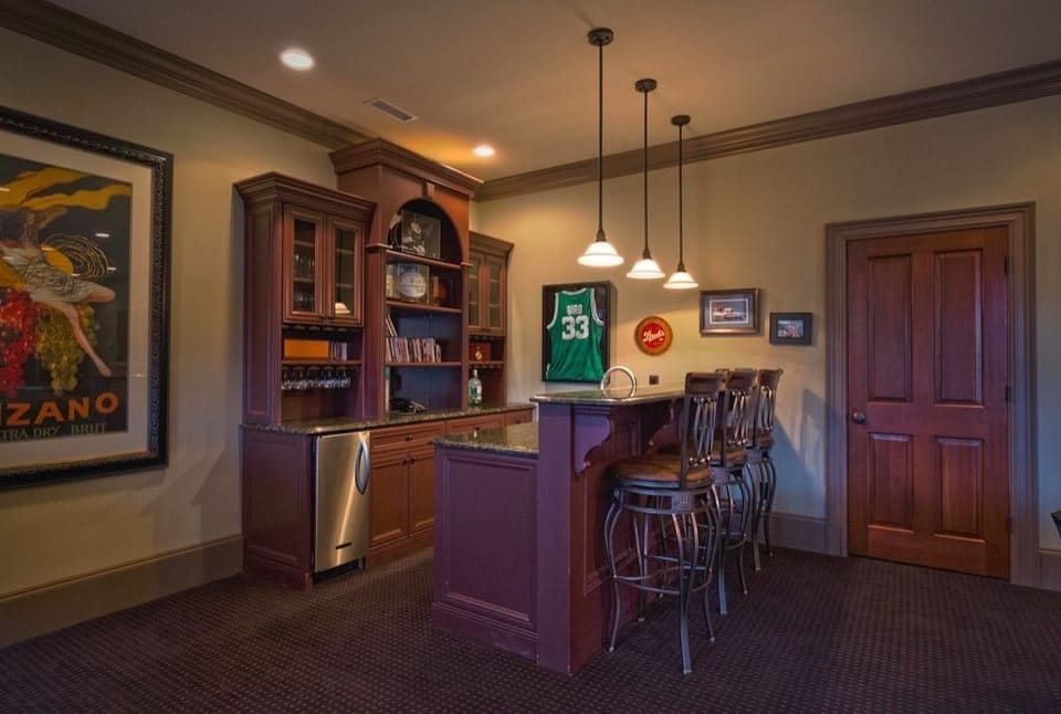 Lower level bar with dedicated icemaker, beverage fridge, sink, and dishwasher 