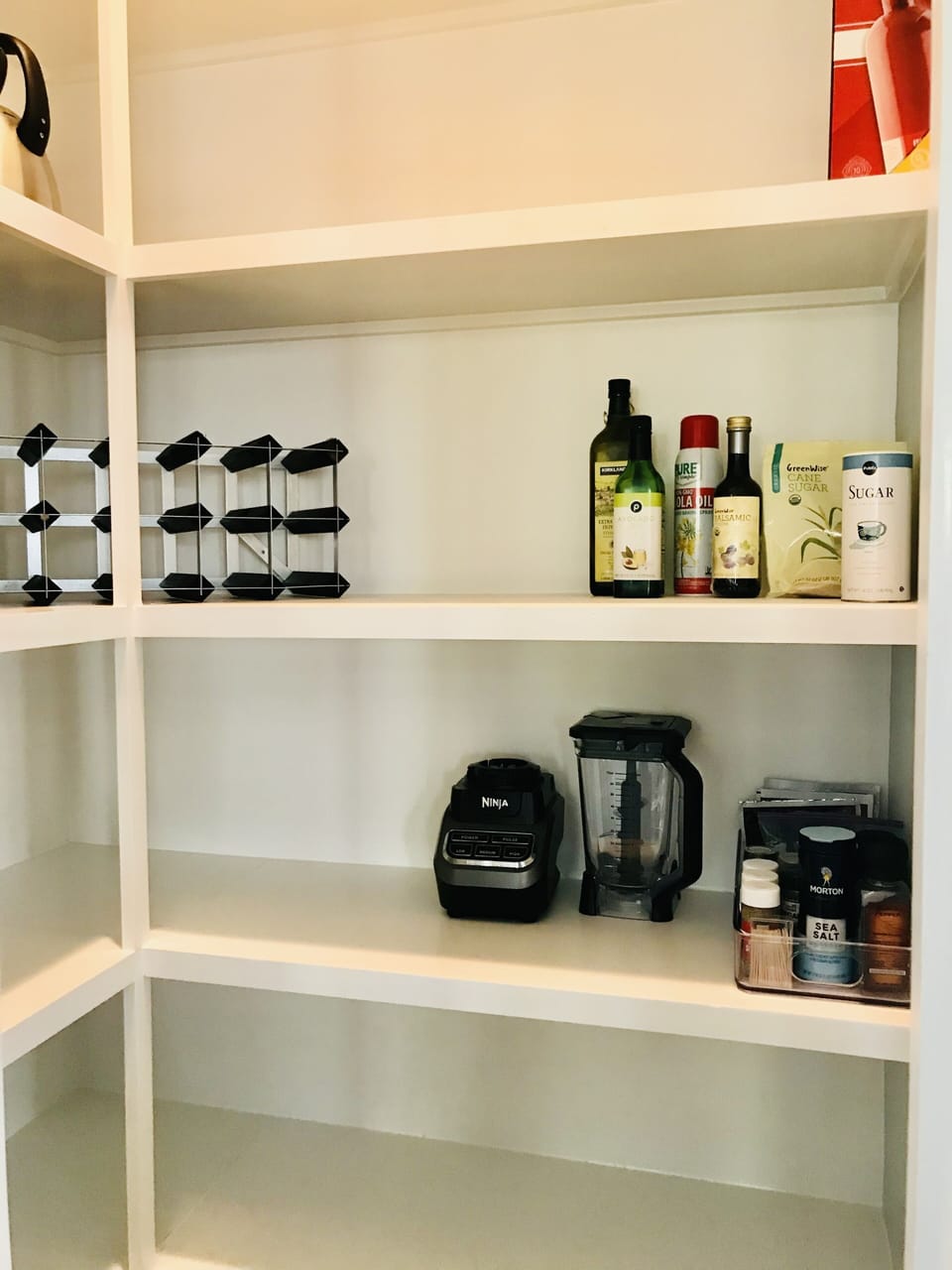 Walk in pantry. Stocked with essential condiments and small appliances.