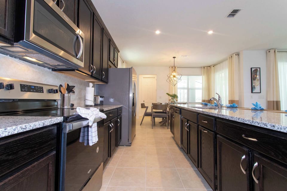 Cook and gather with ease-long double-sided island, ample counter space, and a full suite of stainless appliances leading to the sunny dining nook.