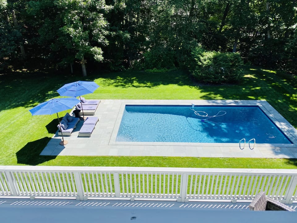 An inviting, heated pool with loungers, umbrellas and lights for nighttime
