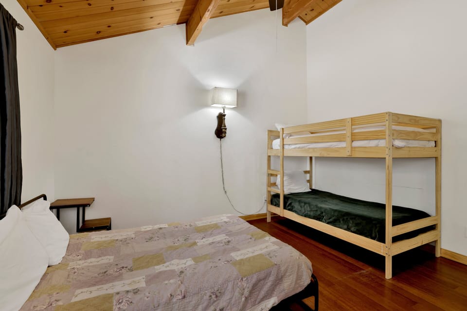 Peaceful cabin bedroom with plush bedding, and beautiful views—ideal for restful nights, cozy mornings, and a relaxing mountain escape.