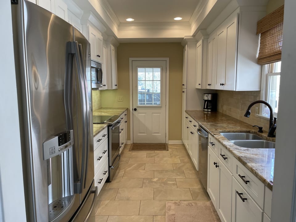 Modern upgraded  kitchen with stainless steel appliances and travertine flooring