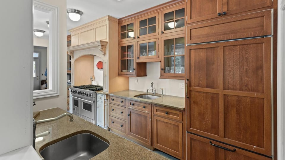 Spacious kitchen with warm wood cabinetry and modern appliances