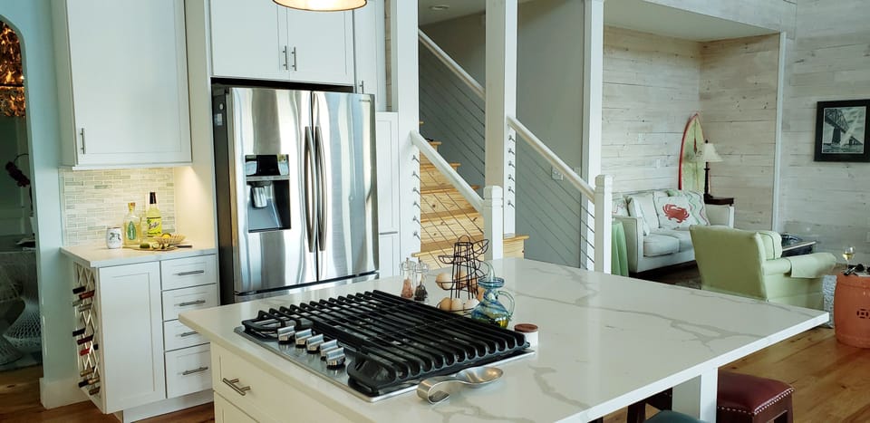 Stove top with refrigerator pictured w/wine rack.  Island seats 4