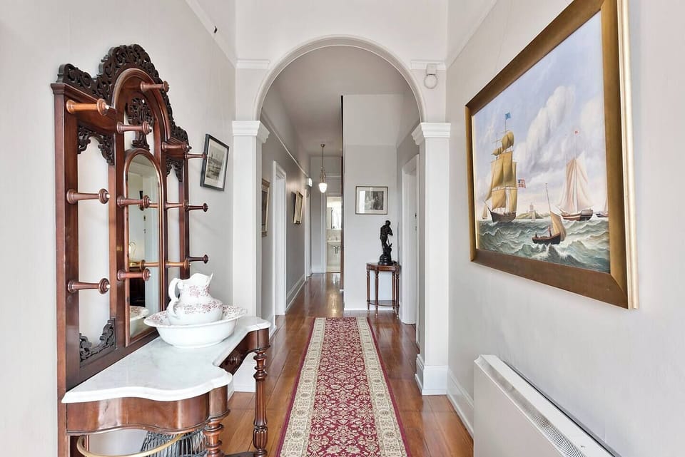 The charming entryway welcomes you with an arched doorway and intricate crown moulding, setting the tone for your stay at Hampden Manor.