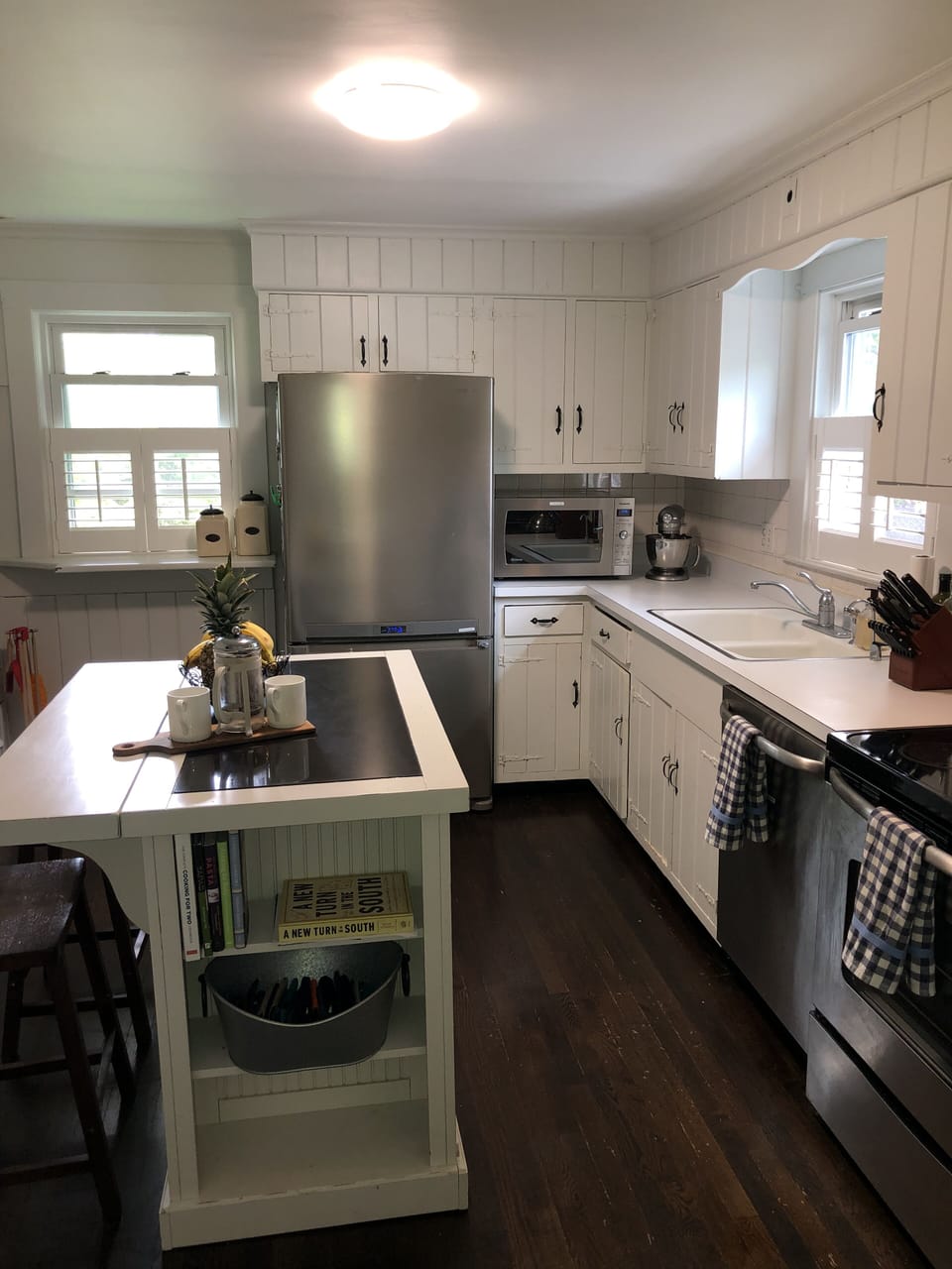 Kitchen w stainless steal appliances, reclaimed hardwood floor, island w/ stools