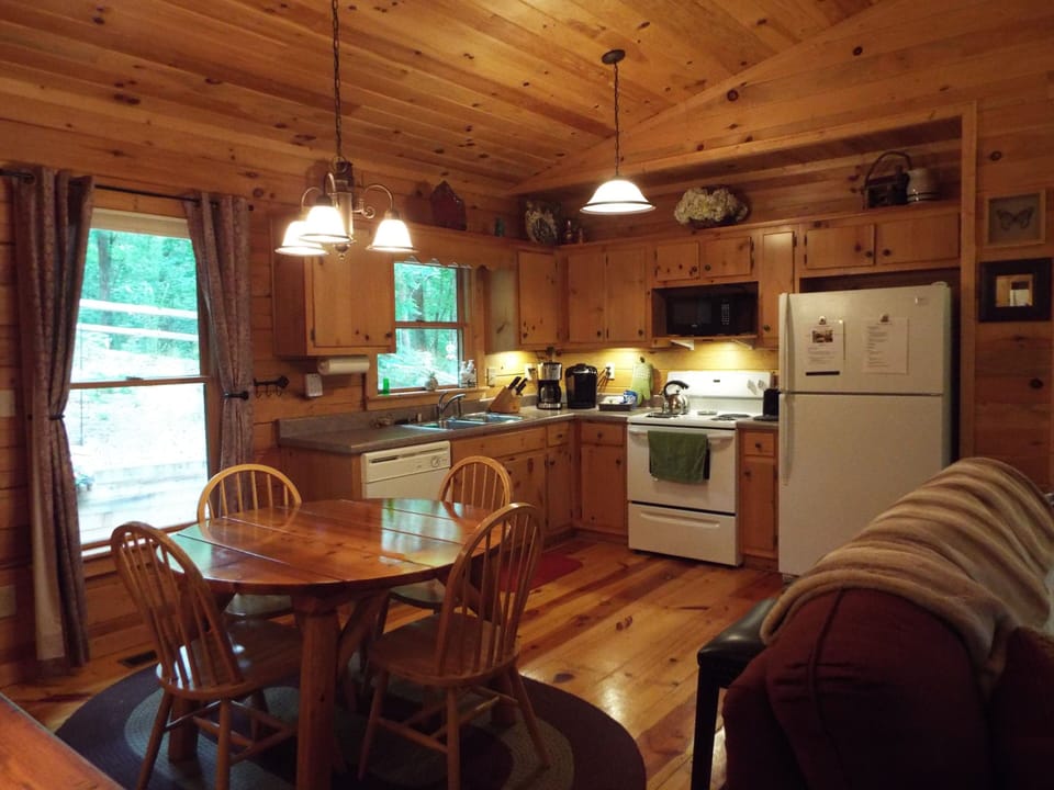 Kitchen includes a dishwasher, stove, oven, pots, pans, dishes, glasses and flatware